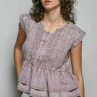 Pink sleeveless embroidered peplum blouse with pintuck front and ruffled hem.