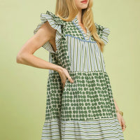 Green patchwork mini dress with flutter sleeves and tiered hem in stripes and dot pattern.