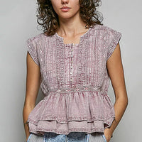 Pink sleeveless embroidered blouse with pintuck detailing and gathered waist peplum.