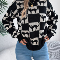 Three-quarter view of black and cream ghost checkerboard knit sweater with ribbed cuffs
