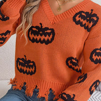 Orange knit V-neck sweater with black jack-o’-lantern pattern and fringe distressed bottom