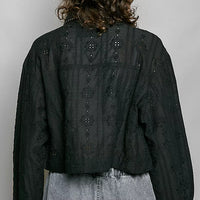 Black cropped eyelet cotton jacket, back view with row of small button details and yoke.