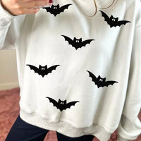 Light gray reversible mock-neck sweatshirt with scattered black bat print and red mock collar