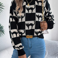 Black and cream ghost checkerboard knit sweater with long sleeves and ribbed neckline