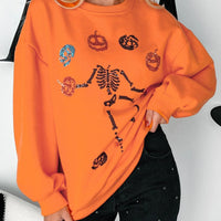 Orange crewneck sweatshirt with Halloween skeleton and pumpkin graphic