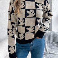 Ghost-pattern checkered round-neck sweater in black and cream, front view.