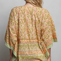 Back of coral floral tie-front blouse with V-neck and striped banded hem