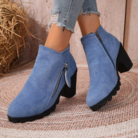 Pair of blue suede ankle boots with block heel and side zipper on round toe