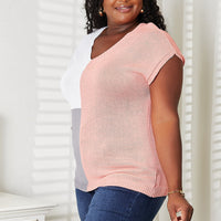 Color-block V-neck knit top in pink with white and gray panels, short sleeves.
