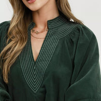 Hunter green corduroy V-neck with contrast stitching and puff sleeve detail