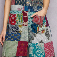 Sleeveless patchwork jumpsuit bodice close-up, multicolor fabric blocks and buttons