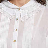 Close-up of ivory button-down collar with lace trim and gold-tone buttons