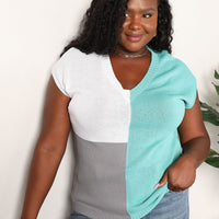 Model wearing turquoise and white color-block V-neck knit top with short sleeves.