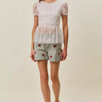 Light-wash denim shorts with rose embroidery, worn with sandals