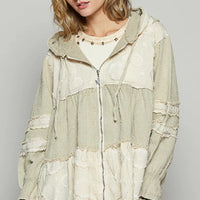 Beige hooded zip jacket with tiered color-block panels and raw, frayed edges