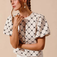 Ivory woven bubble sleeve top with black bow texture pattern, front shoulder detail