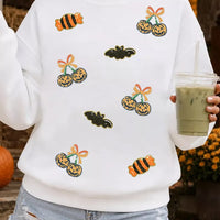 White sequin pullover sweatshirt with Halloween jack-o'-lantern and bat graphics