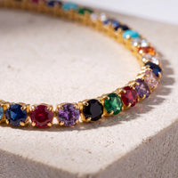 Close-up of gold tennis bracelet with multicolor CZ gemstone row