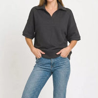 Black collared short-sleeve pullover with half-zip placket and straight hem