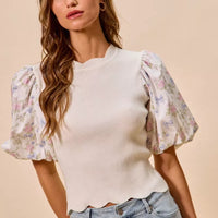 White knit sweater top with floral puff sleeves; scalloped bottom edge