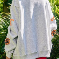 Light gray Halloween sweatshirt back view with orange pumpkin and bow motifs