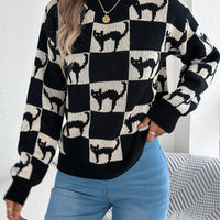Black and cream ghost checkerboard knit sweater with crew neck and ribbed cuffs