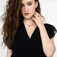 Sapphire pendant necklace with blue square pendant on silver chain at neckline