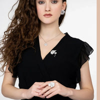 Silver flower stud earrings on model, five layered petals