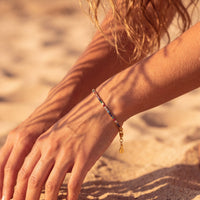 Rainbow CZ tennis bracelet on wrist with gold heart toggle clasp
