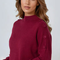 Wine red high-neck jumper with shoulder buttons, neckline and cuff close-up