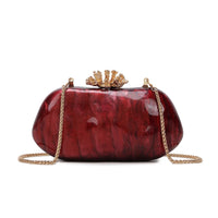 Burgundy box clutch bag with gold coral-inspired clasp and chain shoulder strap
