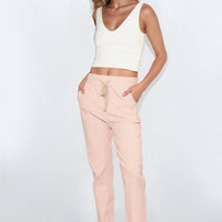 Dusty pink drawstring trousers with side pockets and cuffed ankle hem