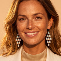 Silver opal teardrop chandelier drop earrings with dangling stones, shown on a model.