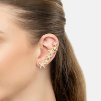 Gold starfish ear climber earring on left ear, close-up of star segments
