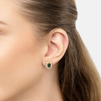 Gold emerald-green gemstone stud earrings with clear halo, side view
