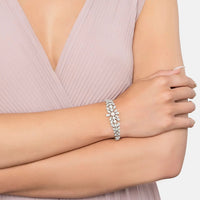 Crystal tennis bracelet with floral leaf design and pearl center on a wrist