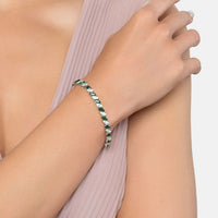 Emerald-green gemstone tennis bracelet on wrist with silver links
