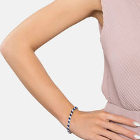 Sapphire tennis bracelet on arm with oval blue stones and silver links