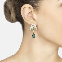 Gold-tone Art Deco drop earrings with emerald-green teardrop dangle on ear