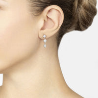 Silver mini triple clover drop earrings on model, three sparkling clover charms