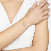 Silver-tone blue opalite bracelet worn on wrist with oval center stone