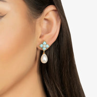 Gold flower clover drop earrings with turquoise enamel and white pearl on ear