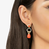 Gold drop earrings on model: red enamel top with black accents and coral teardrop dangle