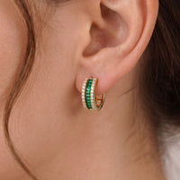 Emerald green baguette huggie hoop earrings with gold posts and crystal sparkle detail