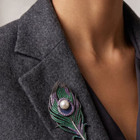 Peacock feather pearl brooch pinned on dark gray blazer, pearl center with green accents