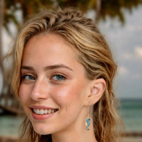 Turquoise seahorse drop earring with gold-tone hook on model, side view