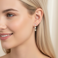 Gold clover drop earrings with three small crystal clovers on ear