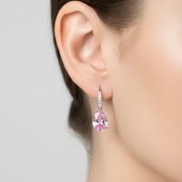 Morganite pink teardrop earrings with a pavé drop on a model's ear