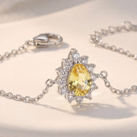 Silver bracelet close-up with oval yellow center stone and crystal halo