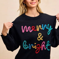 Black pullover sweater with multicolor tinsel "Merry & Bright" lettering front